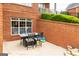 Patio with outdoor dining table and chairs, adjacent to brick wall and lush greenery at 713 Birkdale Blvd, Carrollton, GA 30116