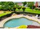 Private pool with a stone trim and black fencing is surrounded by mature landscaping at 713 Birkdale Blvd, Carrollton, GA 30116
