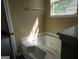 Bathroom with a bathtub and jacuzzi jets underneath a window, winterized for protection at 5799 Eagles Feather Ln, Riverdale, GA 30274