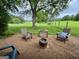 Backyard seating area features fire pit, Adirondack chairs and views of a large grassy field at 360 Morgan Mill Rd, Brooks, GA 30205