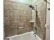Bathroom features a tub-shower combo with tan tiled surround, hand shower, and updated fixtures at 360 Morgan Mill Rd, Brooks, GA 30205