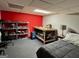 Bedroom with a red accent wall, shelving units, a table, and carpeted floors at 360 Morgan Mill Rd, Brooks, GA 30205