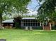 Exterior view showcasing two chairs on the lawn and screened-in porch at 360 Morgan Mill Rd, Brooks, GA 30205