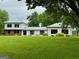 Charming home with lush green lawn, beautiful landscaping, and a metal roof at 360 Morgan Mill Rd, Brooks, GA 30205
