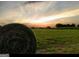 Picturesque field with a large hay bale silhouetted against the sunset at 360 Morgan Mill Rd, Brooks, GA 30205
