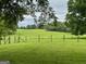 A picturesque open field is enclosed by a classic wooden fence under a serene sky at 360 Morgan Mill Rd, Brooks, GA 30205
