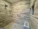 Sleek walk-in shower with designer tile walls, corner shelves and mosaic tiled flooring at 360 Morgan Mill Rd, Brooks, GA 30205