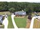 Aerial view of a brick home with a well-maintained lawn and mature trees at 245 Edenwylde Ct, Hampton, GA 30228