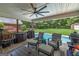 This is a covered patio with outdoor seating, a fan, and a view of the fenced-in backyard and pool at 245 Edenwylde Ct, Hampton, GA 30228