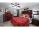 This is a comfy bedroom featuring a ceiling fan, natural light, and classic wooden furniture at 245 Edenwylde Ct, Hampton, GA 30228