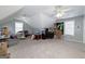This is a spacious bonus room with two windows, a ceiling fan, and carpet flooring throughout at 245 Edenwylde Ct, Hampton, GA 30228