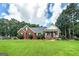 Charming brick home features a covered front porch and a well-manicured lawn at 245 Edenwylde Ct, Hampton, GA 30228