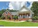 Charming brick home with a well-manicured lawn, covered porch, and lush landscaping at 245 Edenwylde Ct, Hampton, GA 30228