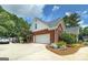 Side view of brick home, showcasing a two-car garage and driveway with landscaping at 245 Edenwylde Ct, Hampton, GA 30228