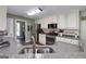 Modern kitchen with stainless steel appliances, granite counters, ample storage, and a view to the breakfast room at 245 Edenwylde Ct, Hampton, GA 30228