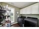 Functional laundry room featuring modern appliances, storage shelving, and a bright window at 245 Edenwylde Ct, Hampton, GA 30228
