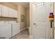Efficient laundry area with washer, dryer, and storage cabinets for a functional space at 326 Elkins Place, Peachtree City, GA 30269