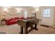 Finished basement featuring a foosball table, red sofa, and ample space for recreation and relaxation at 3502 Village Green Dr, Roswell, GA 30075