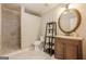 Neutral bathroom with walk-in shower, stylish vanity with round mirror, and elegant fixtures at 3502 Village Green Dr, Roswell, GA 30075
