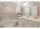 Neutral bathroom featuring bathtub and shower combination with a glass door and white vanity at 3502 Village Green Dr, Roswell, GA 30075
