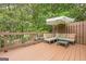 Wooden deck featuring lounge furniture, patio umbrella, and overlooks a lush backyard at 3502 Village Green Dr, Roswell, GA 30075