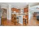 Open kitchen design with barstool seating, hardwood floors, and cherry wood cabinets at 3502 Village Green Dr, Roswell, GA 30075