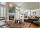 Cozy living room with a grand fireplace, a statement peacock painting, and comfortable leather furniture at 3502 Village Green Dr, Roswell, GA 30075