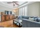 Relaxing living room featuring a comfortable blue sectional, hardwood floors, and natural light at 3502 Village Green Dr, Roswell, GA 30075