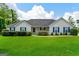 Charming single-story home with blue shutters, manicured lawn, and lush green landscaping at 227 Ferguson Ave, Locust Grove, GA 30248