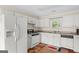 Kitchen features white appliances, cabinets and wood-look flooring at 227 Ferguson Ave, Locust Grove, GA 30248