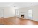Bright living room with hardwood floors, a fireplace, a ceiling fan, and a door to the backyard at 227 Ferguson Ave, Locust Grove, GA 30248