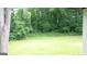 View of grassy backyard with large trees, creating a natural and private outdoor space at 6178 Graceland Cir, Morrow, GA 30260