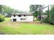 Home exterior and grassy backyard with large trees, showing a peaceful setting at 6178 Graceland Cir, Morrow, GA 30260