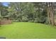 Lush backyard features mature trees and green lawn at 128 Rubicon Rd, Peachtree City, GA 30269