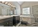 Elegant bathroom featuring dual vanities, a large tub with jets, and a glass shower at 128 Rubicon Rd, Peachtree City, GA 30269