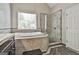 Luxurious bathroom with a soaking tub under a window and a separate glass-enclosed shower at 128 Rubicon Rd, Peachtree City, GA 30269