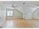 Large bedroom with angled ceiling, window, fan, and light-colored wood floors at 128 Rubicon Rd, Peachtree City, GA 30269