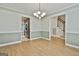 Open dining room with wood floors, chandelier, and view to kitchen at 128 Rubicon Rd, Peachtree City, GA 30269