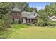 Beautiful brick home with a well-kept lawn and flowering bushes at 128 Rubicon Rd, Peachtree City, GA 30269
