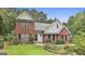 Charming two-story brick home with a manicured lawn and mature landscaping at 128 Rubicon Rd, Peachtree City, GA 30269