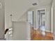 Upstairs hallway with hardwood floors and view of the staircase with decorative hanging light at 128 Rubicon Rd, Peachtree City, GA 30269