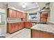 Well-lit kitchen with granite countertops, wood cabinets, stainless appliances and tile flooring at 128 Rubicon Rd, Peachtree City, GA 30269