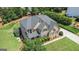 Aerial view of a large home with mature trees, lush landscaping, and a well maintained lawn at 4830 Northridge Dr, Cumming, GA 30041