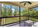 Relaxing back porch with a ceiling fan, offering scenic views of lush greenery and blue skies at 4830 Northridge Dr, Cumming, GA 30041