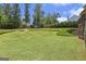 Spacious backyard features lush green grass and mature trees, perfect for outdoor activities at 4830 Northridge Dr, Cumming, GA 30041