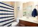 Well-lit bathroom featuring a vanity with a dark wood cabinet and a blue striped shower curtain at 4830 Northridge Dr, Cumming, GA 30041