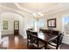 Elegant dining room featuring hardwood floors, decorative columns, and ample natural light from large windows at 4830 Northridge Dr, Cumming, GA 30041