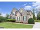 Side view of a beautiful two-story home with stone and brick facade and a well manicured lawn at 4830 Northridge Dr, Cumming, GA 30041