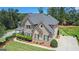 Elevated view of a large home with mature trees, lush landscaping, and a well maintained lawn at 4830 Northridge Dr, Cumming, GA 30041