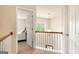 Upstairs hallway features neutral carpet, white banisters, and an open doorway to a bedroom at 4830 Northridge Dr, Cumming, GA 30041